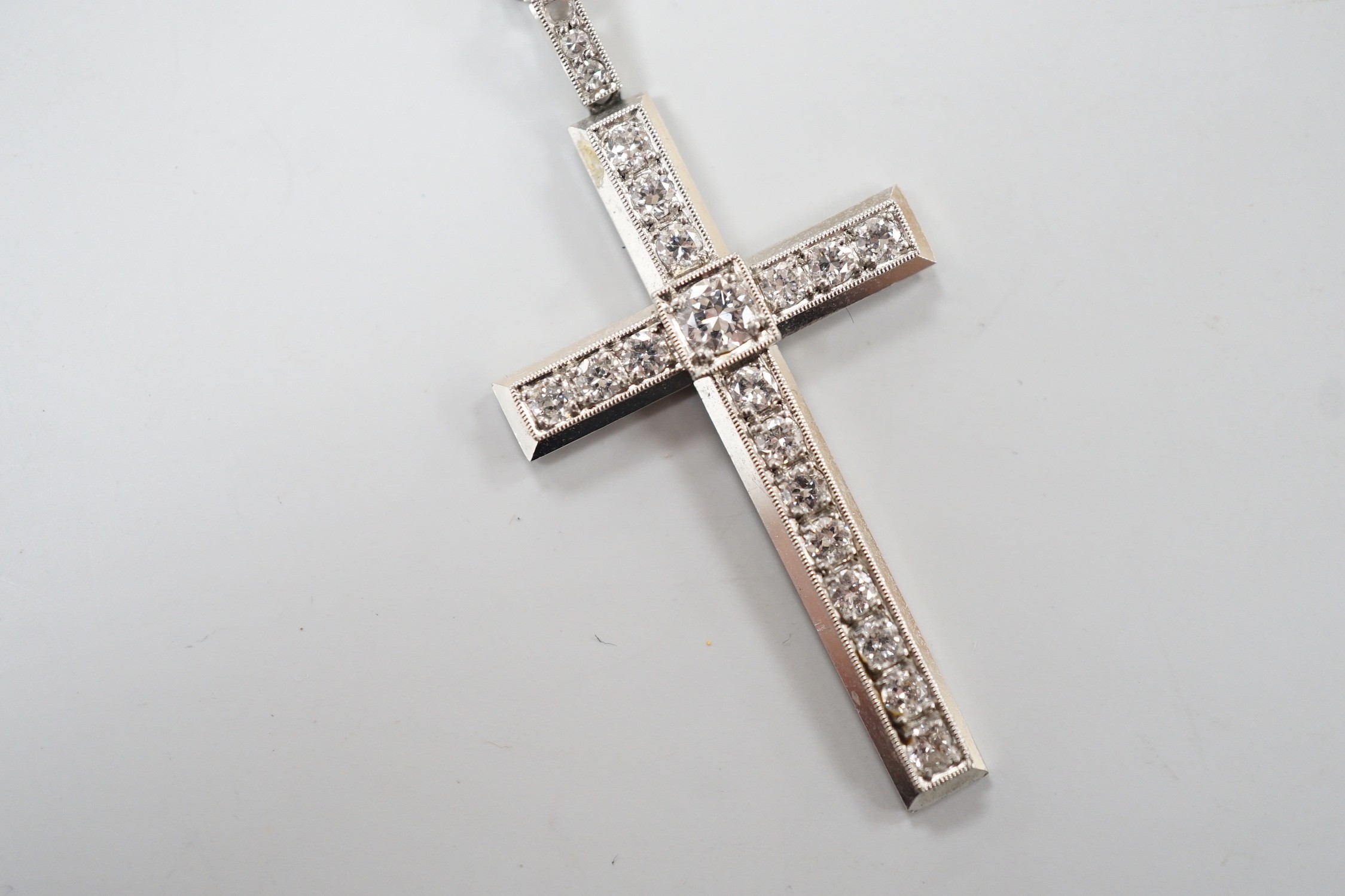 A white metal(stamped platin) and diamond set cross pendant, overall 46mm, on a white metal chain, 70cm, gross weight 12.1 grams